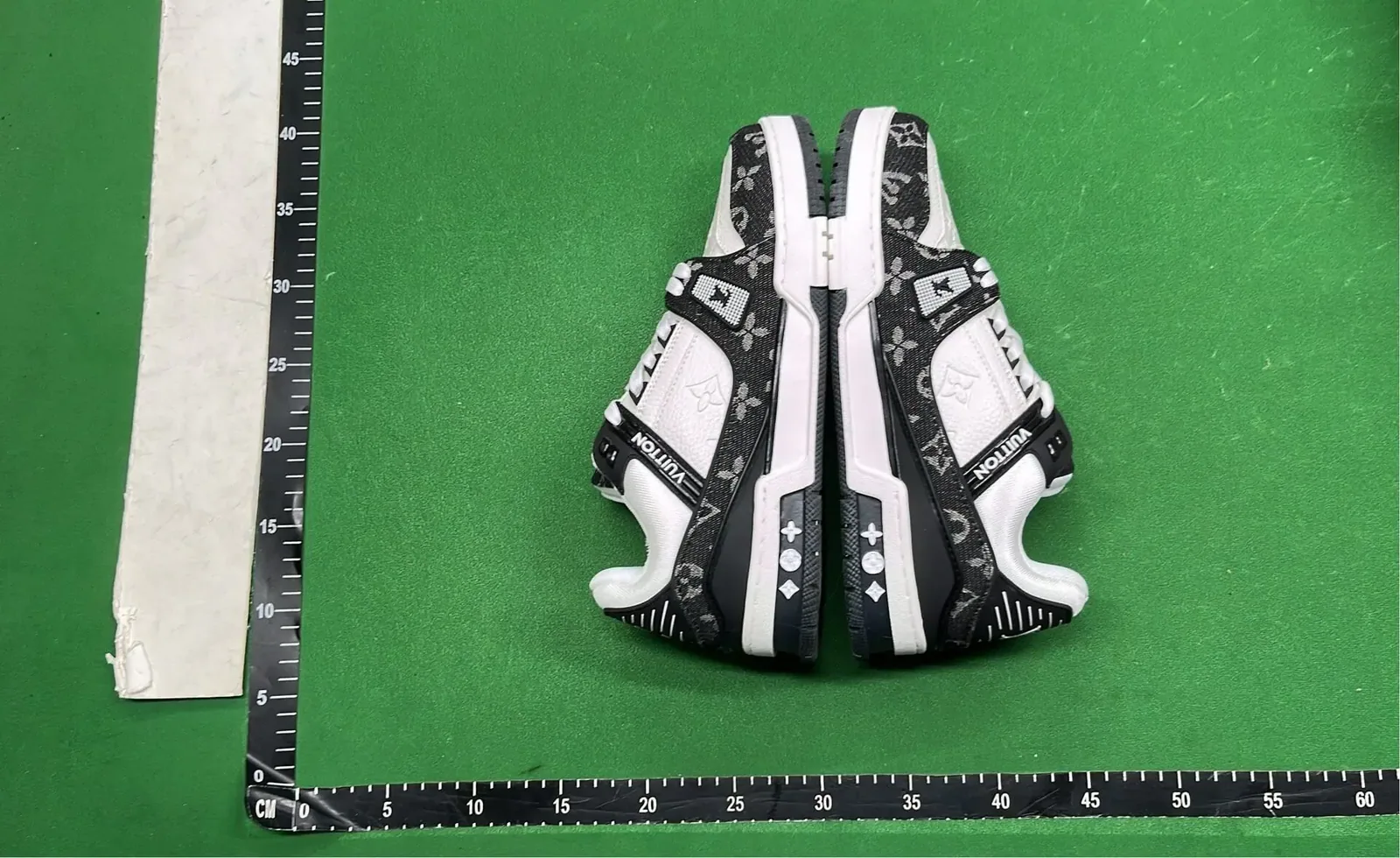 Kakobuy QC shoes rear heel view beside a centimeter ruler